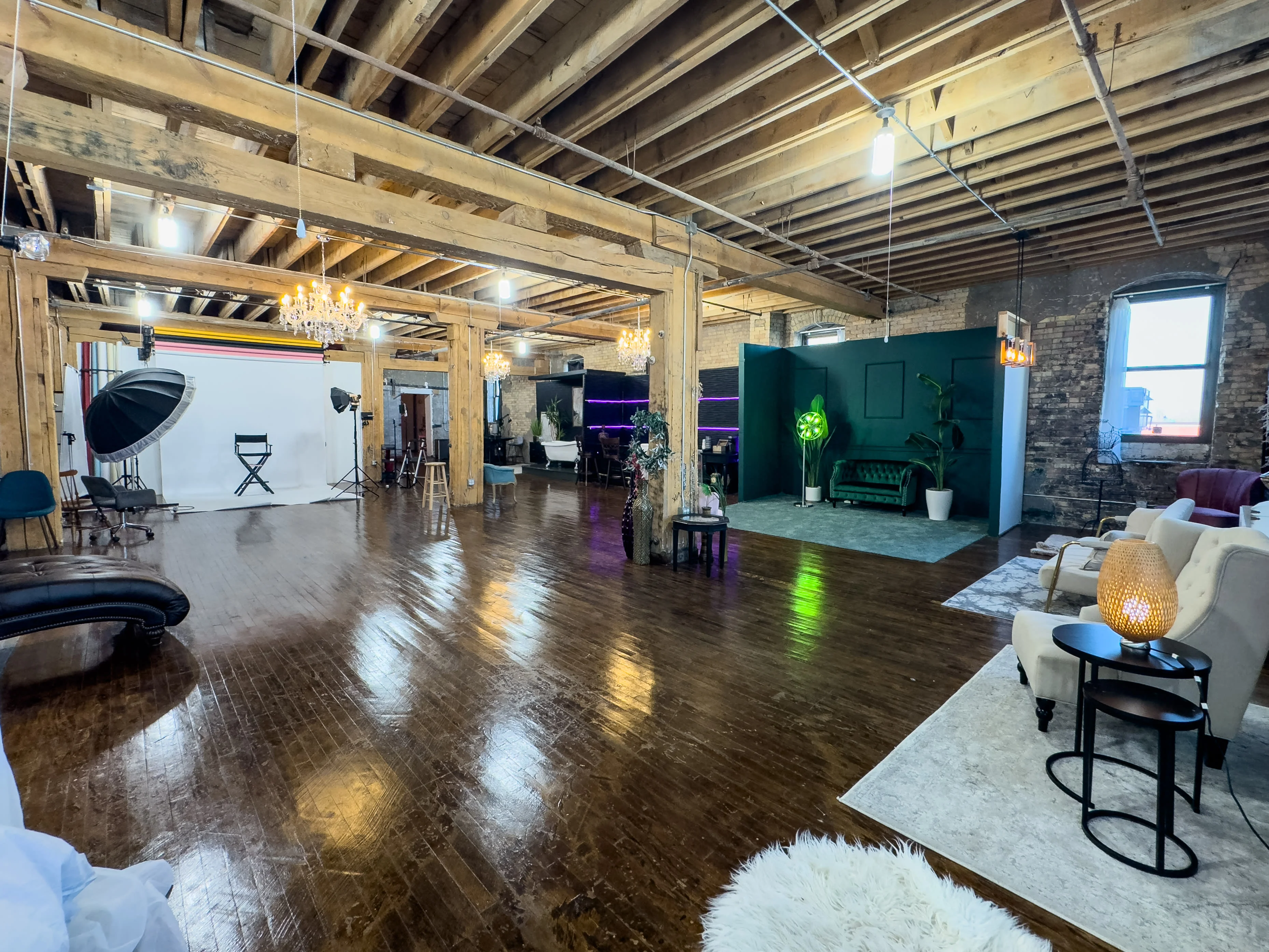 Wide view of Studio A with brick walls, wood beams and several sets