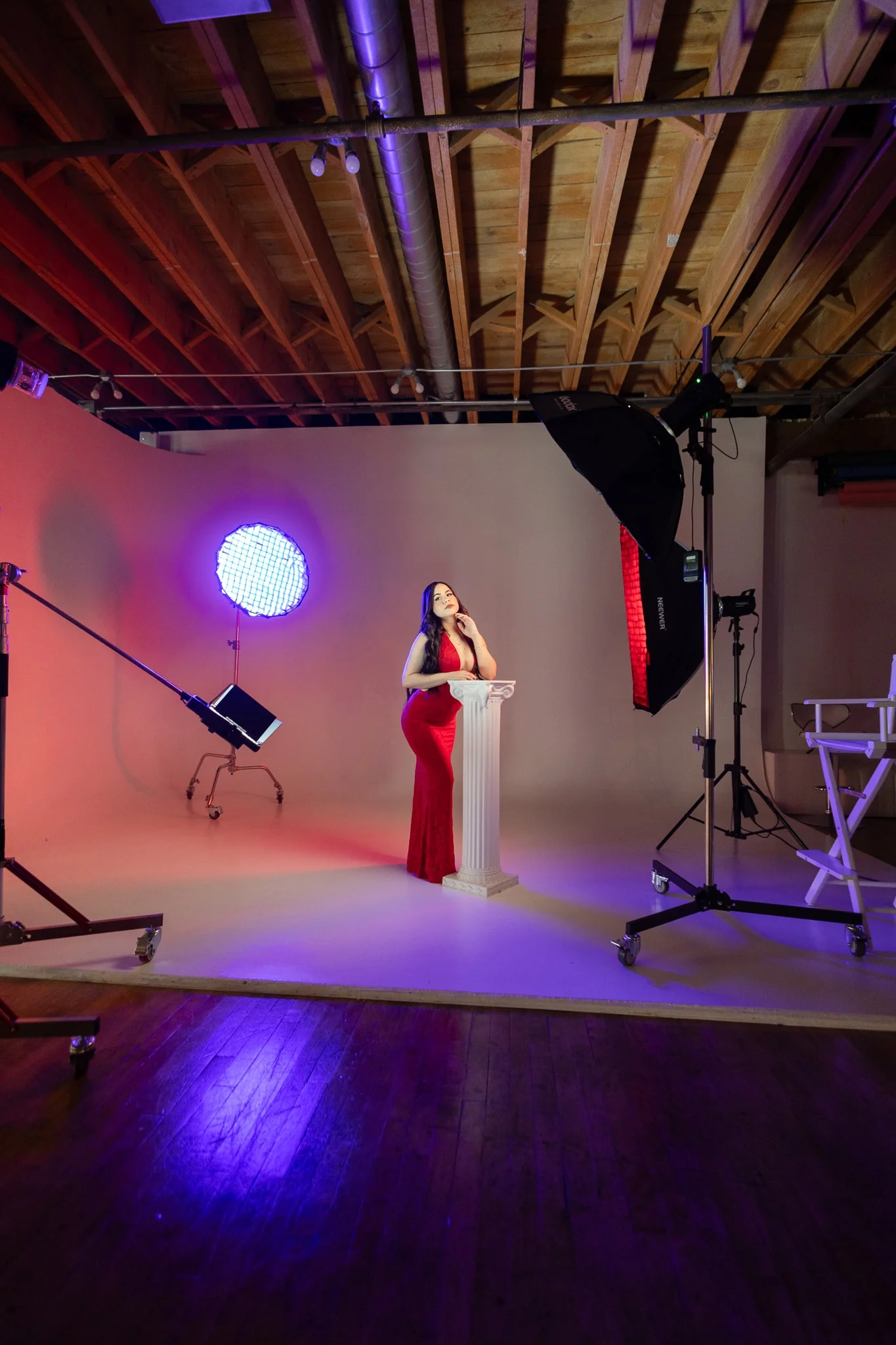 Model in a red gown lit by a spotlight on the cyc